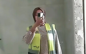 Turkish bird with headscarf who loops on the camera and puts on a show at the construction site